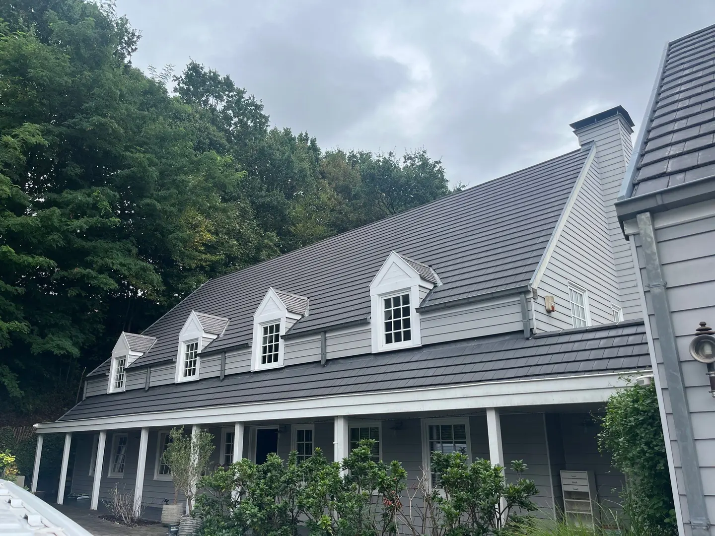 Maison avec toiture et bardage gris après intervention